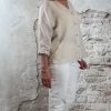 Linnen blouse zandkleur met opgerolde mouw, gecombineerd met ecru 3D-jeans en gouden sleehaksandaal – zijkant